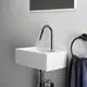 Weißes, rechteckiges Waschbecken mit einem hochglänzenden Chrom-Wasserhahn, montiert an einer hellen Wand. Handtuchhalter und dunkles Handtuch sichtbar. Ideal Standard Produkt.